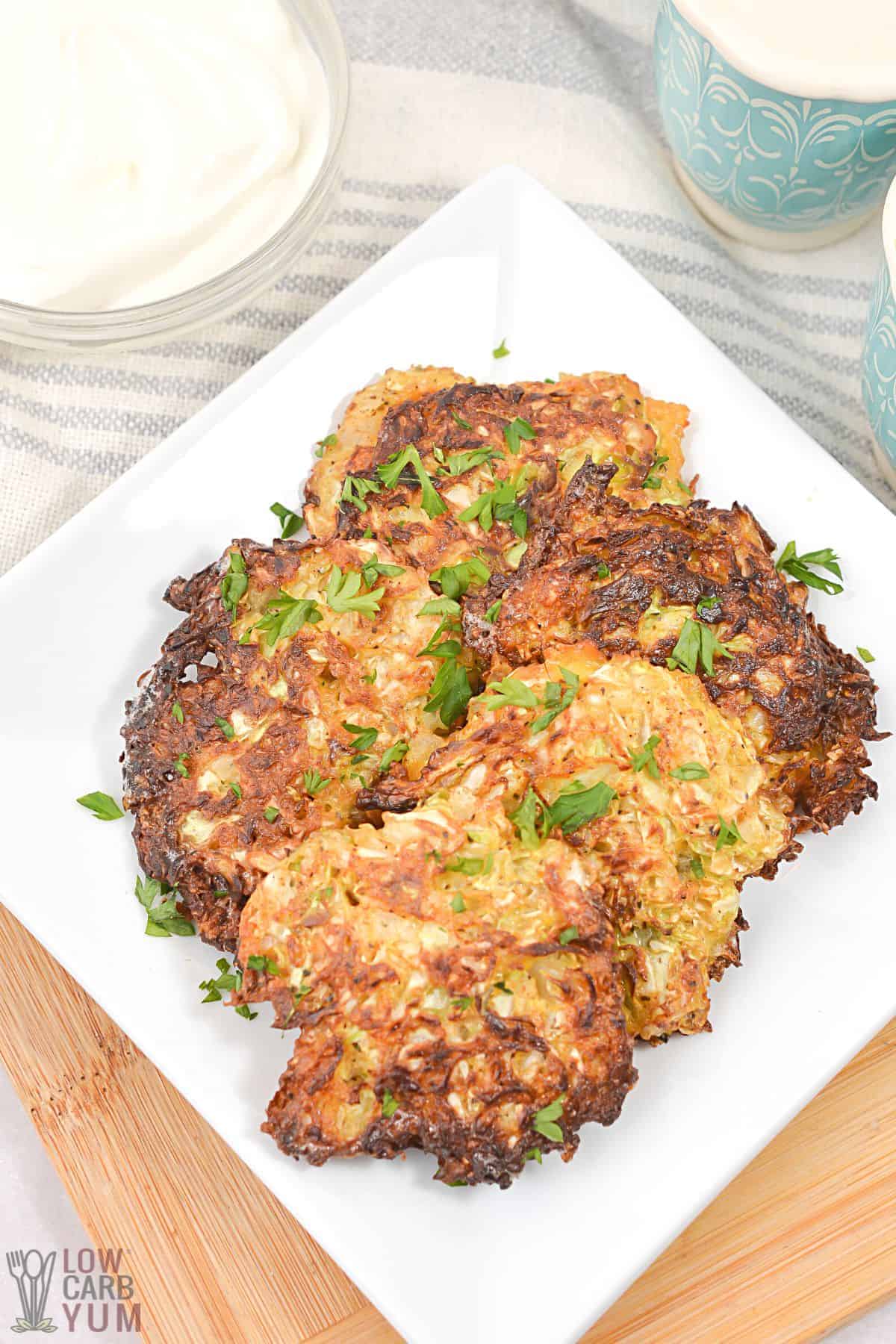 cabbage hash browns on square white plate.