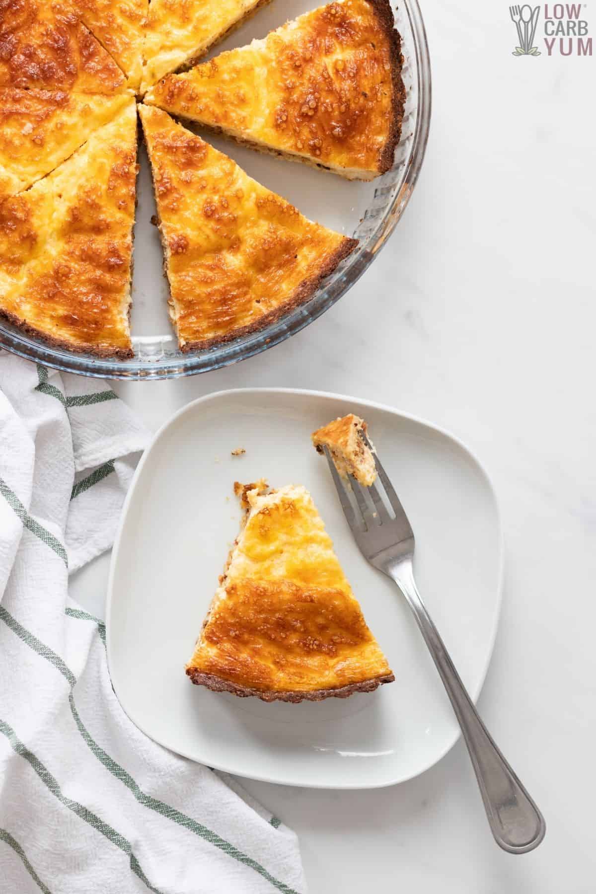 overhead of sliced quiche with slice on plate.