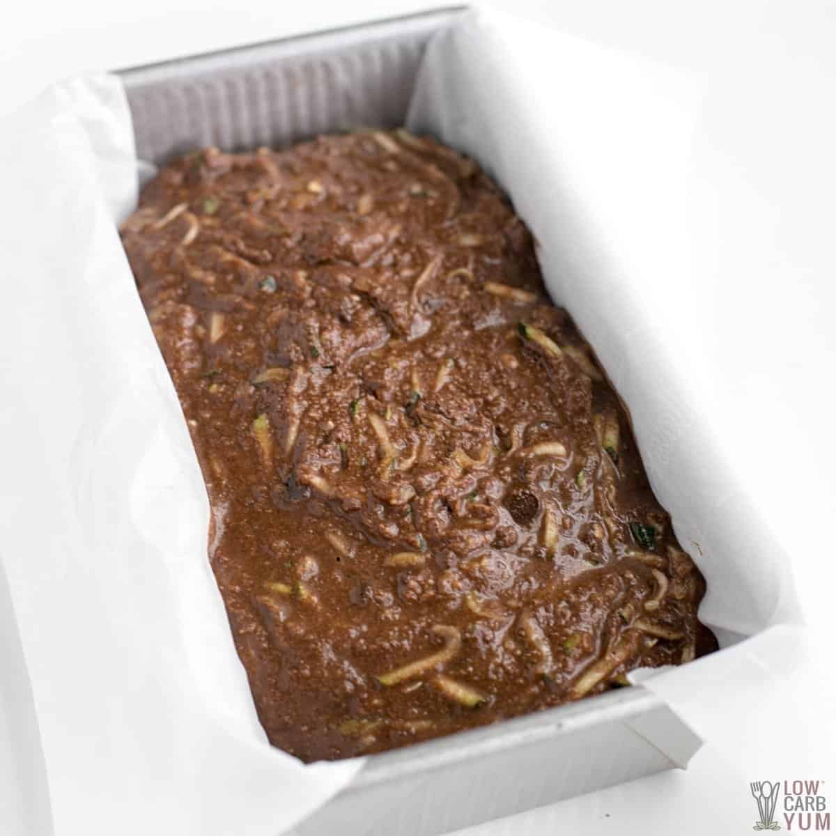 unbaked chocolate zucchini bread batter in lined loaf pan.