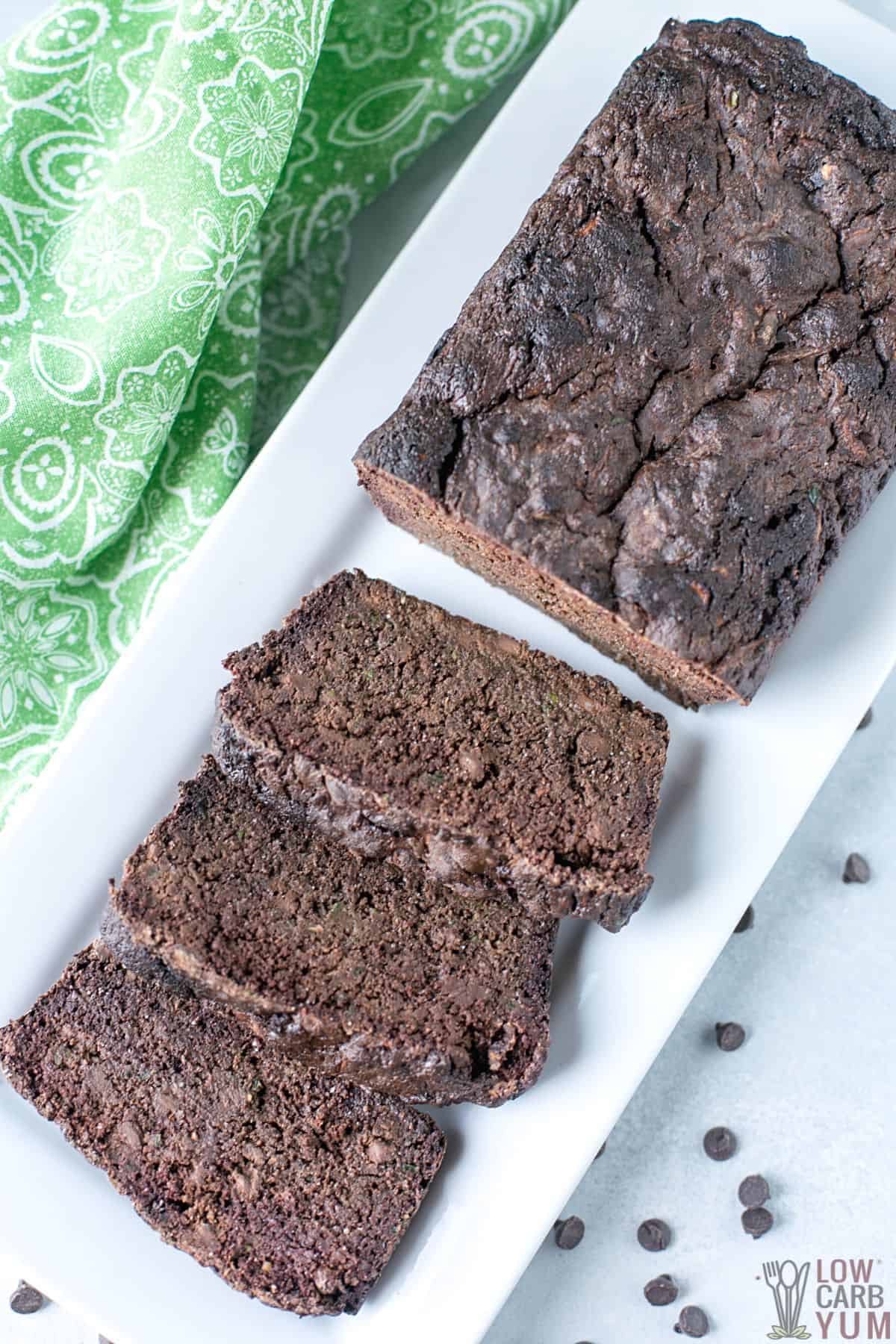 chocolate zucchini bread sliced on white rectangular plate.