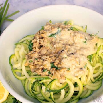 creamy clam sauce over zoodles in white bowl.