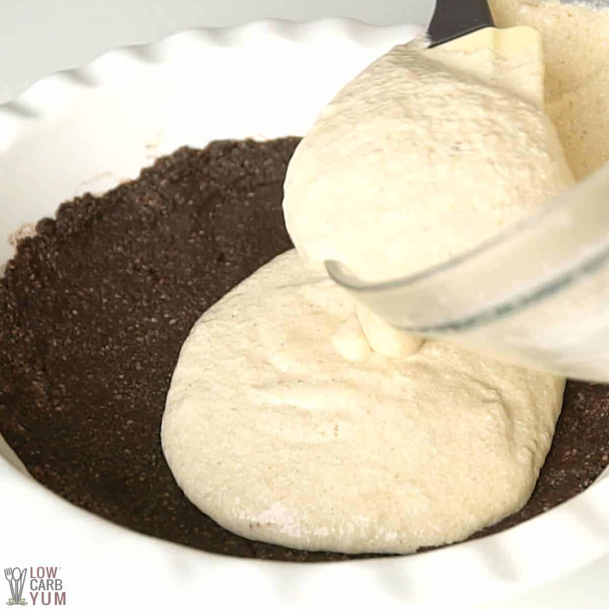 pouring peanut butter filling into chocolate pie crust.