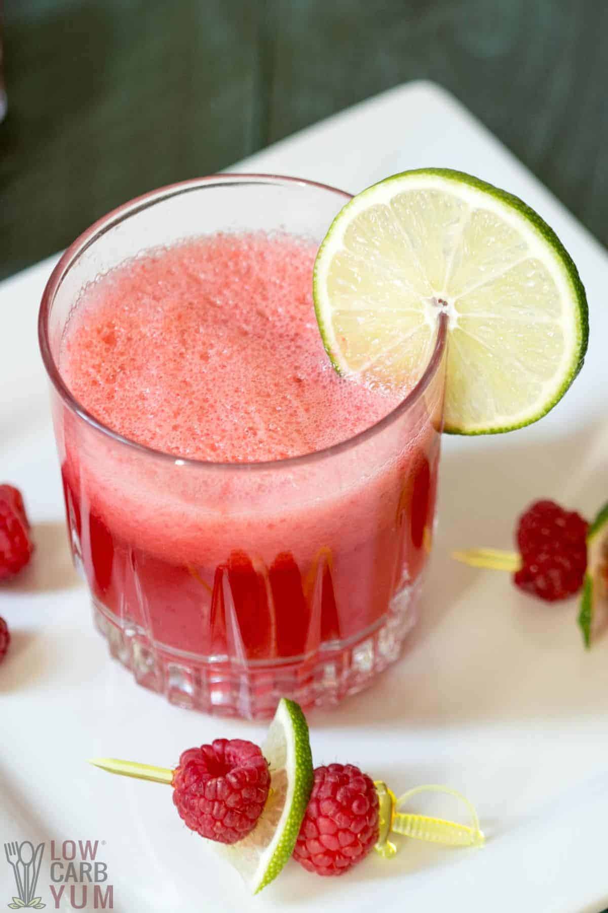 raspberry limeade in glass with garnishing.