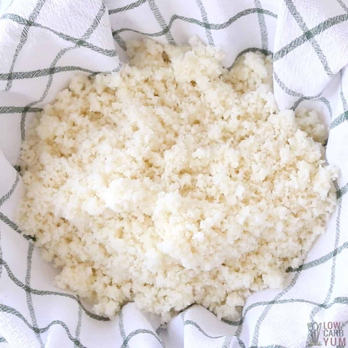 cooked cauliflower rice in kitchen towel.