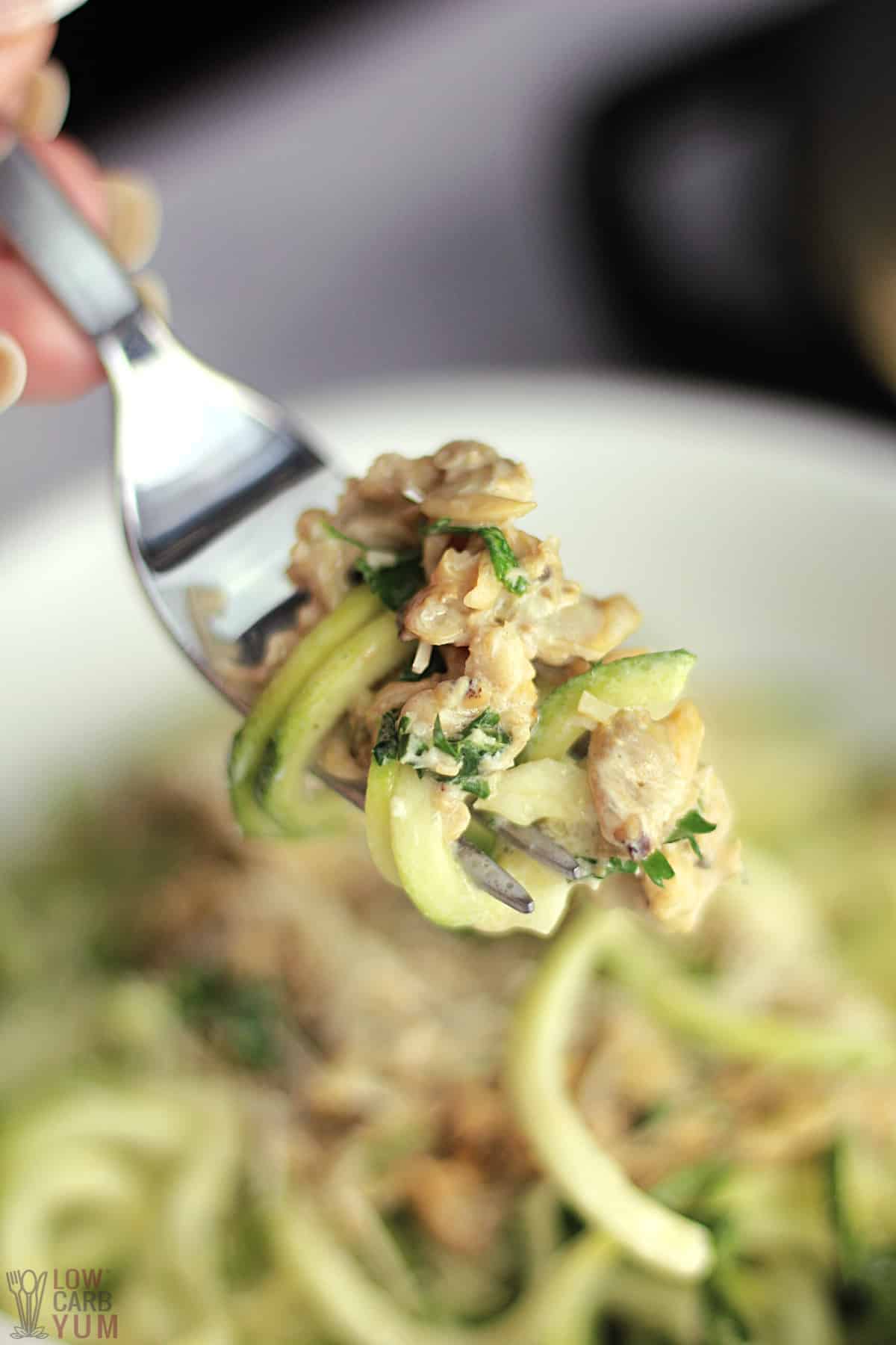 creamy white clam sauce and zoodles on fork.