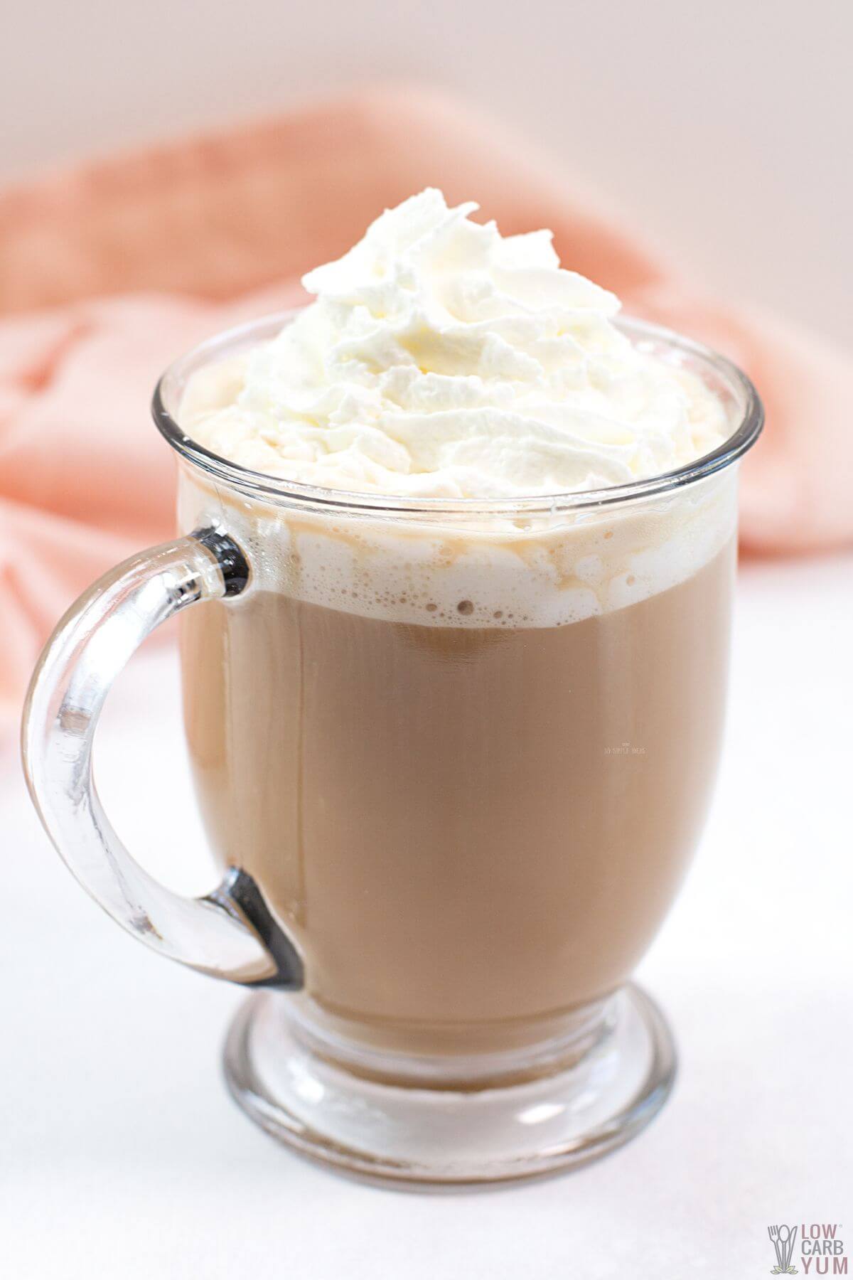 cookie butter latte in glass mug topped with whipped cream.