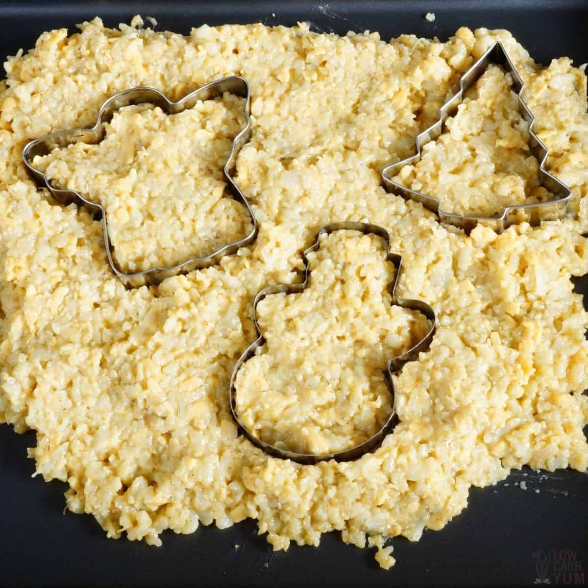 cookie cutters on cauliflower pizza crust mixture.