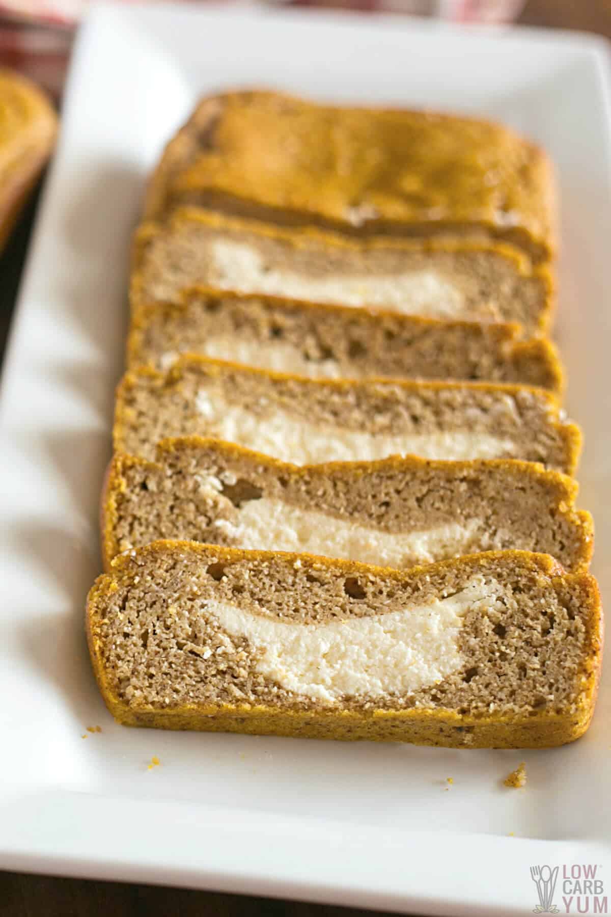slices of cream cheese pumpkin bread on white platter.
