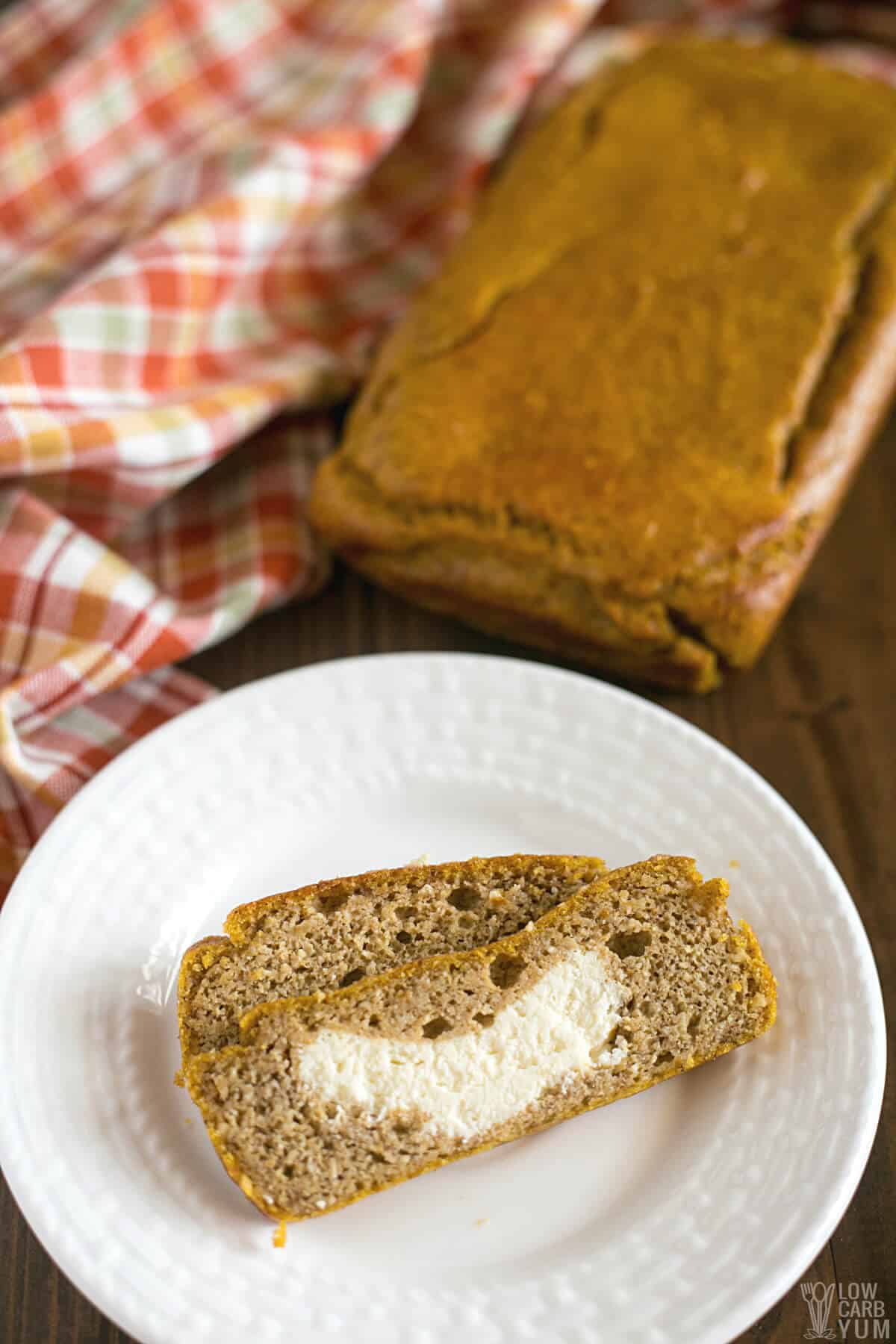 slice of cream cheese filled pumpkin next to a loaf