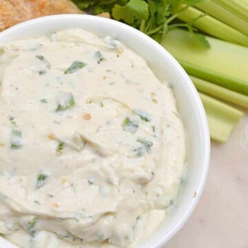 a bowl of jalapeno ranch dip with celery and pork rinds