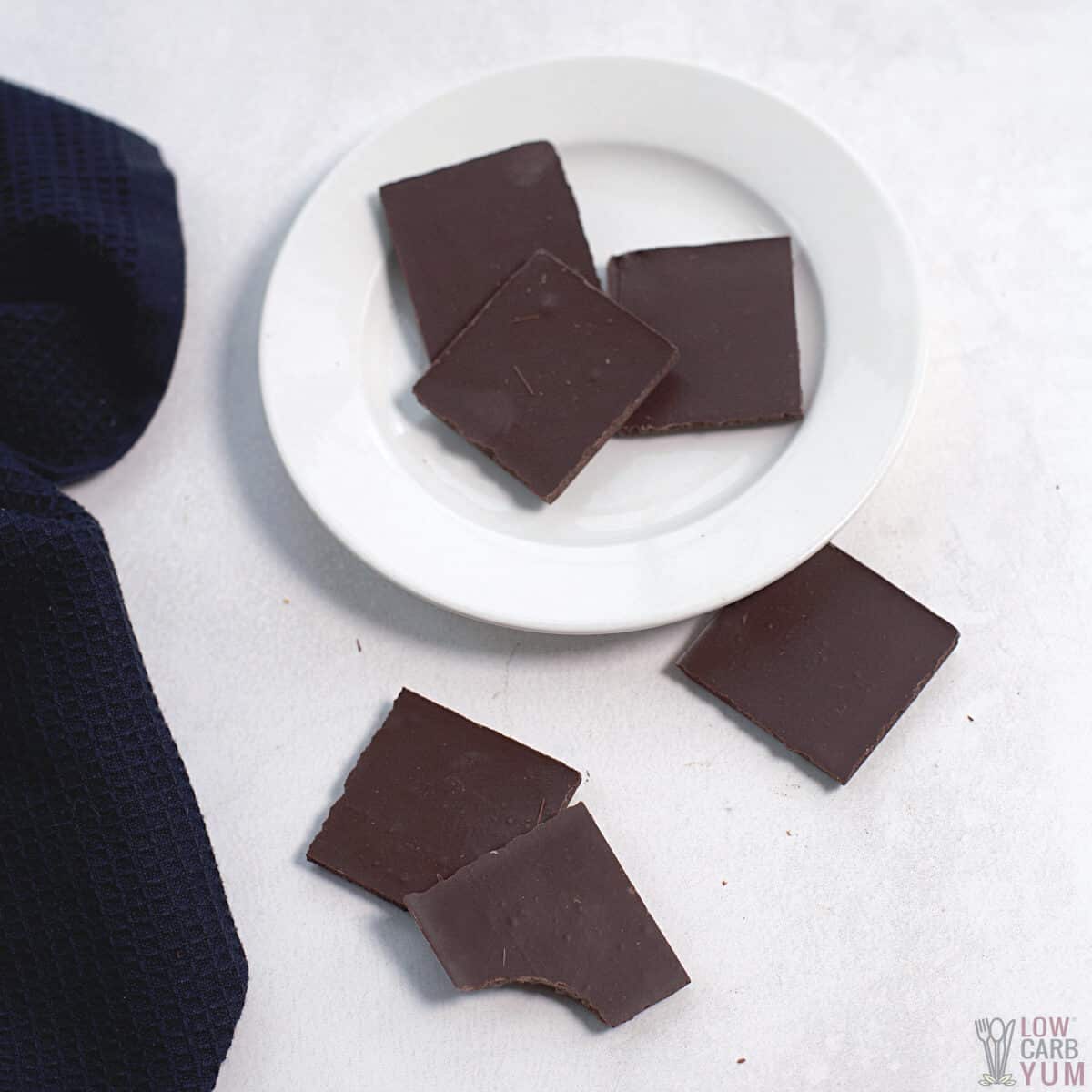 keto dark chocolate squares with one bitten.