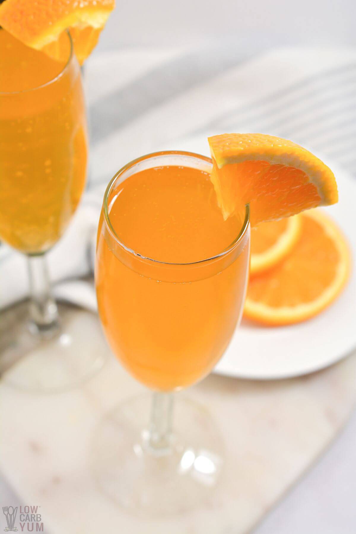 keto mimosa in champagne glasses with orange slices.