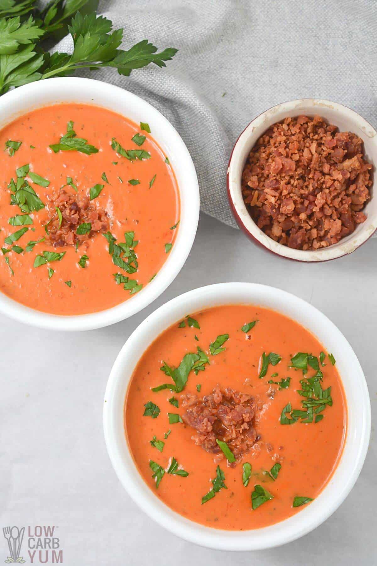 keto tomato soup in bowls topped with bacon.