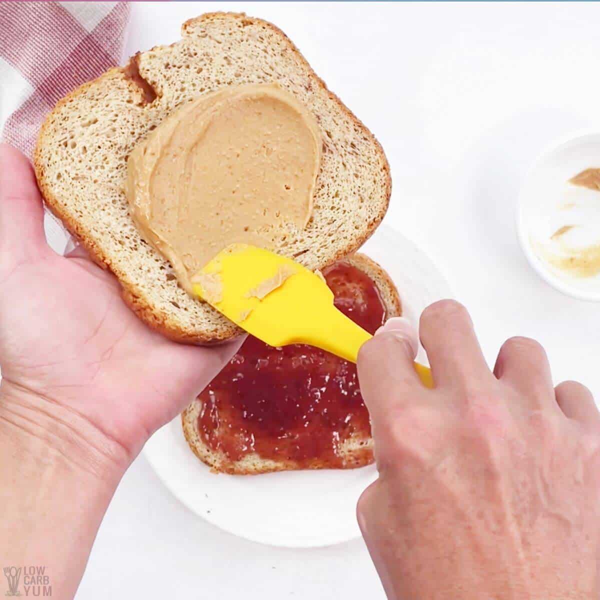 spreading peanut butter on bread slice.