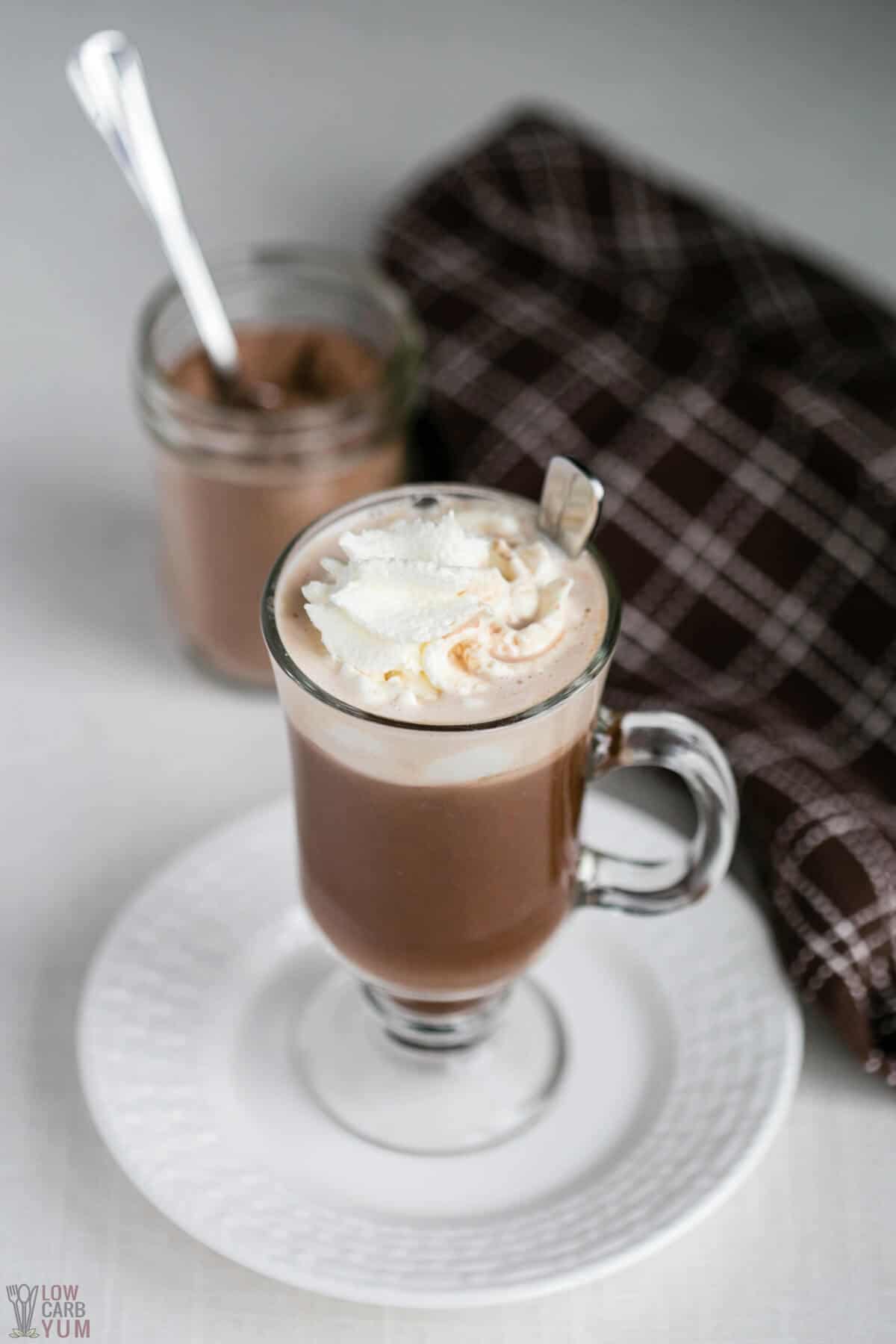 dairy free hot chocolate in glass mug with mix in jar.