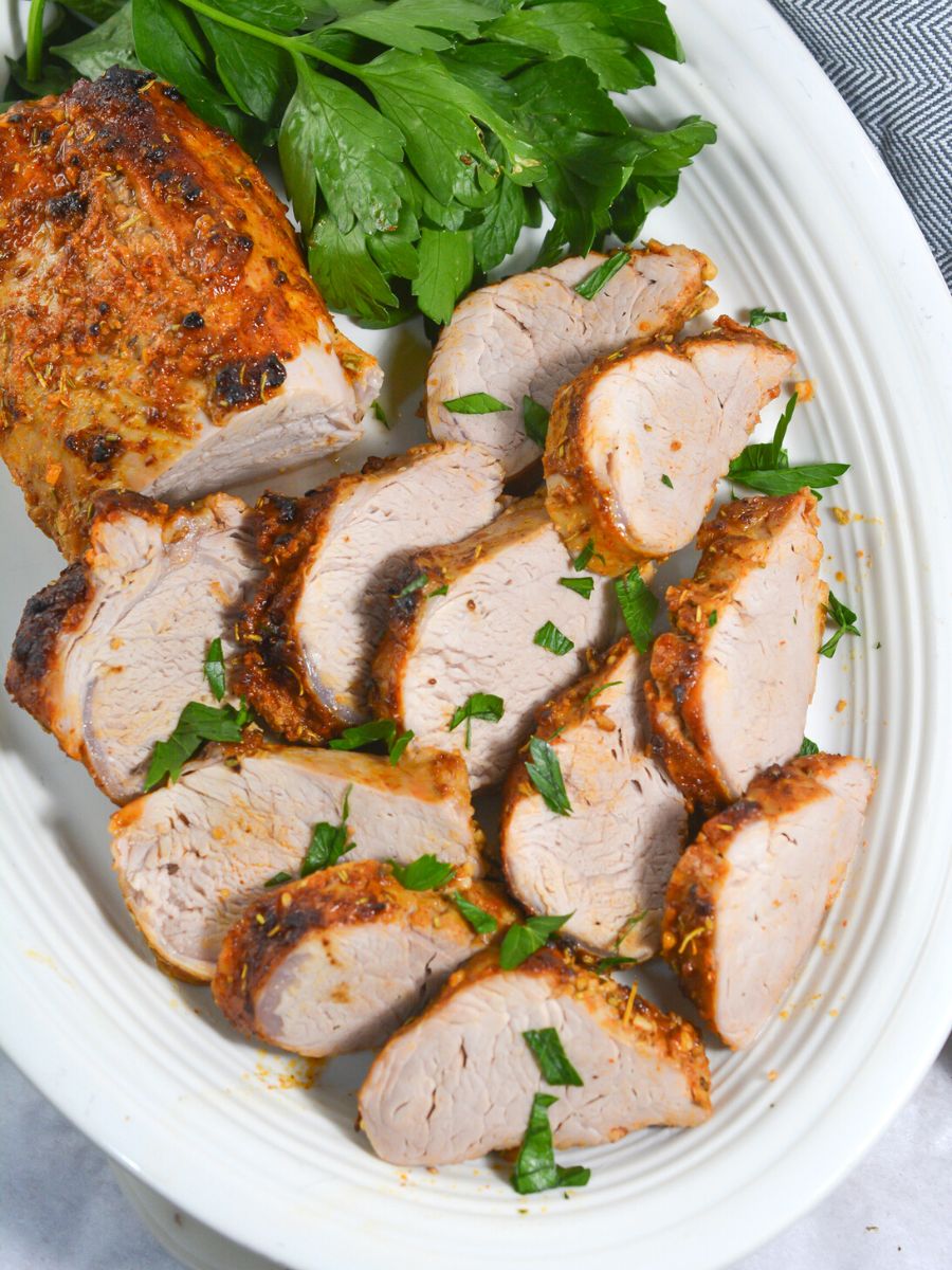 sliced pork tenderloin on a white platter