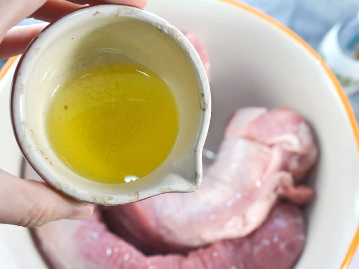 adding olive oil to pork tenderloin