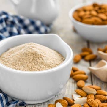 a bowl of almond flour with raw almonds