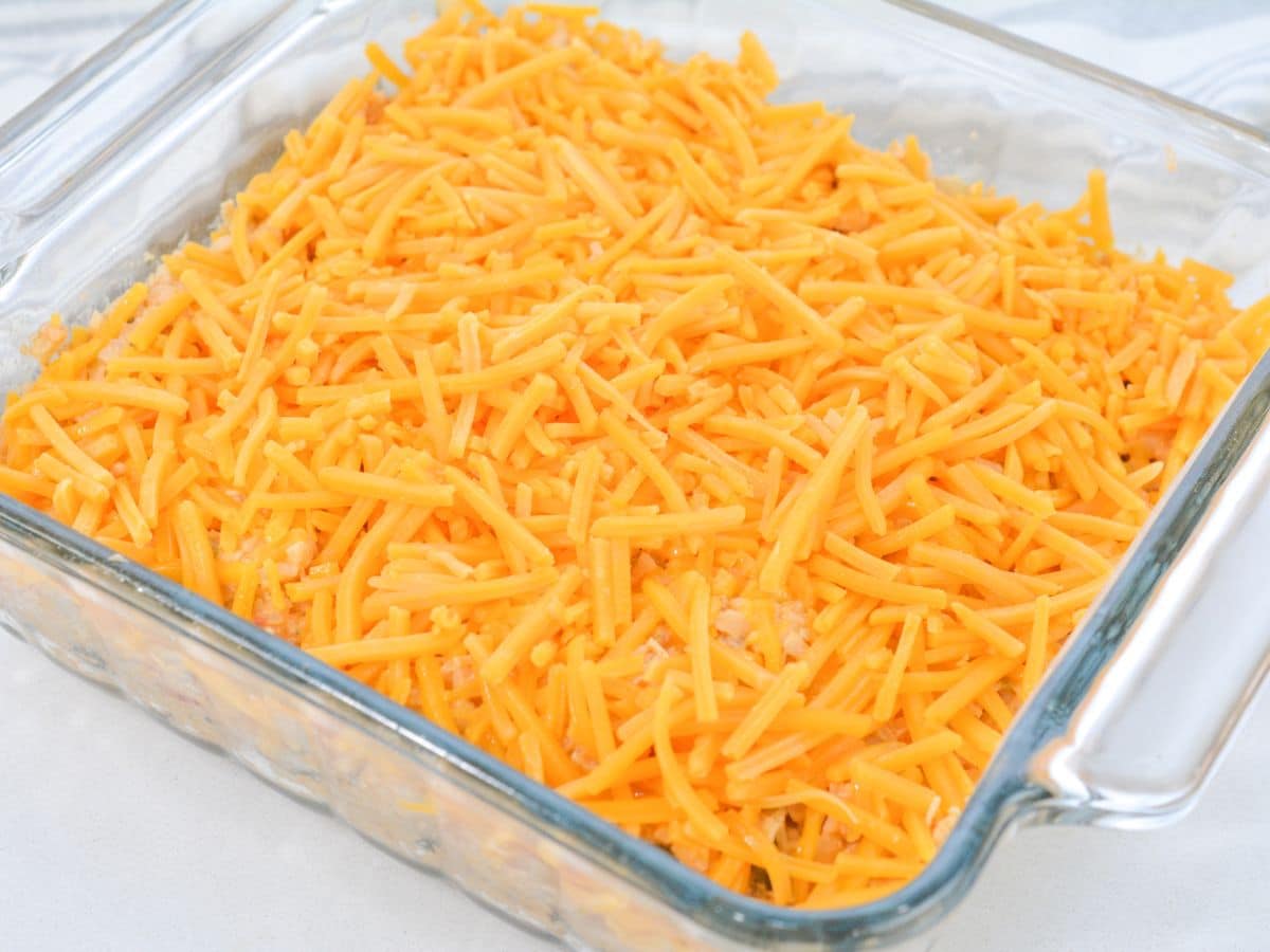 adding shredded cheese for chicken taco casserole