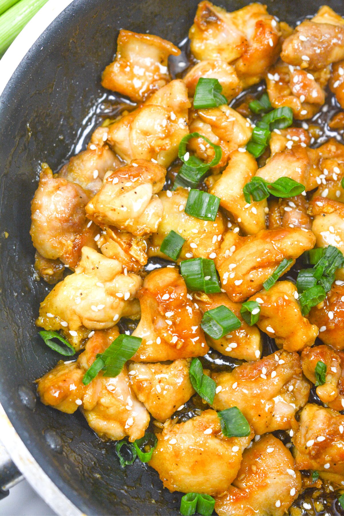 sesame chicken with sauce and green onions