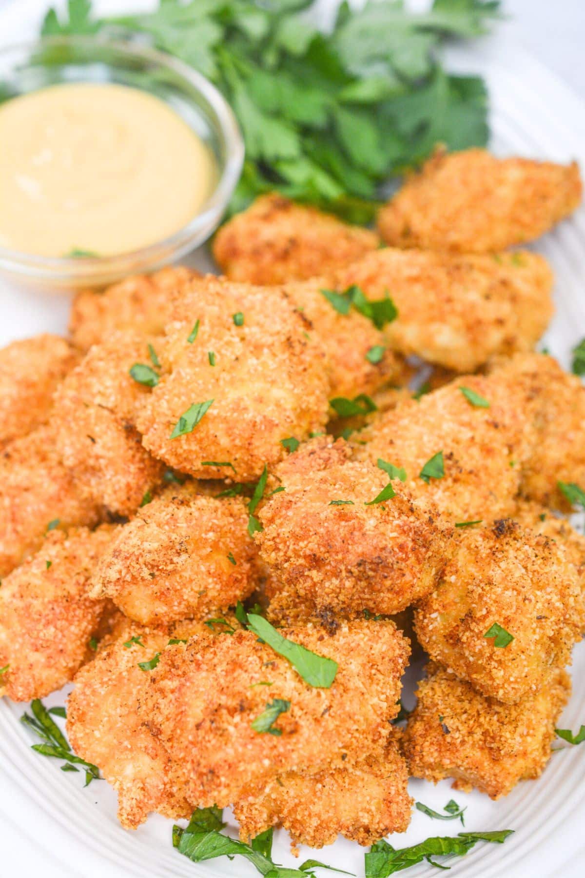 chicken nuggets on a white platter with dipping sauce