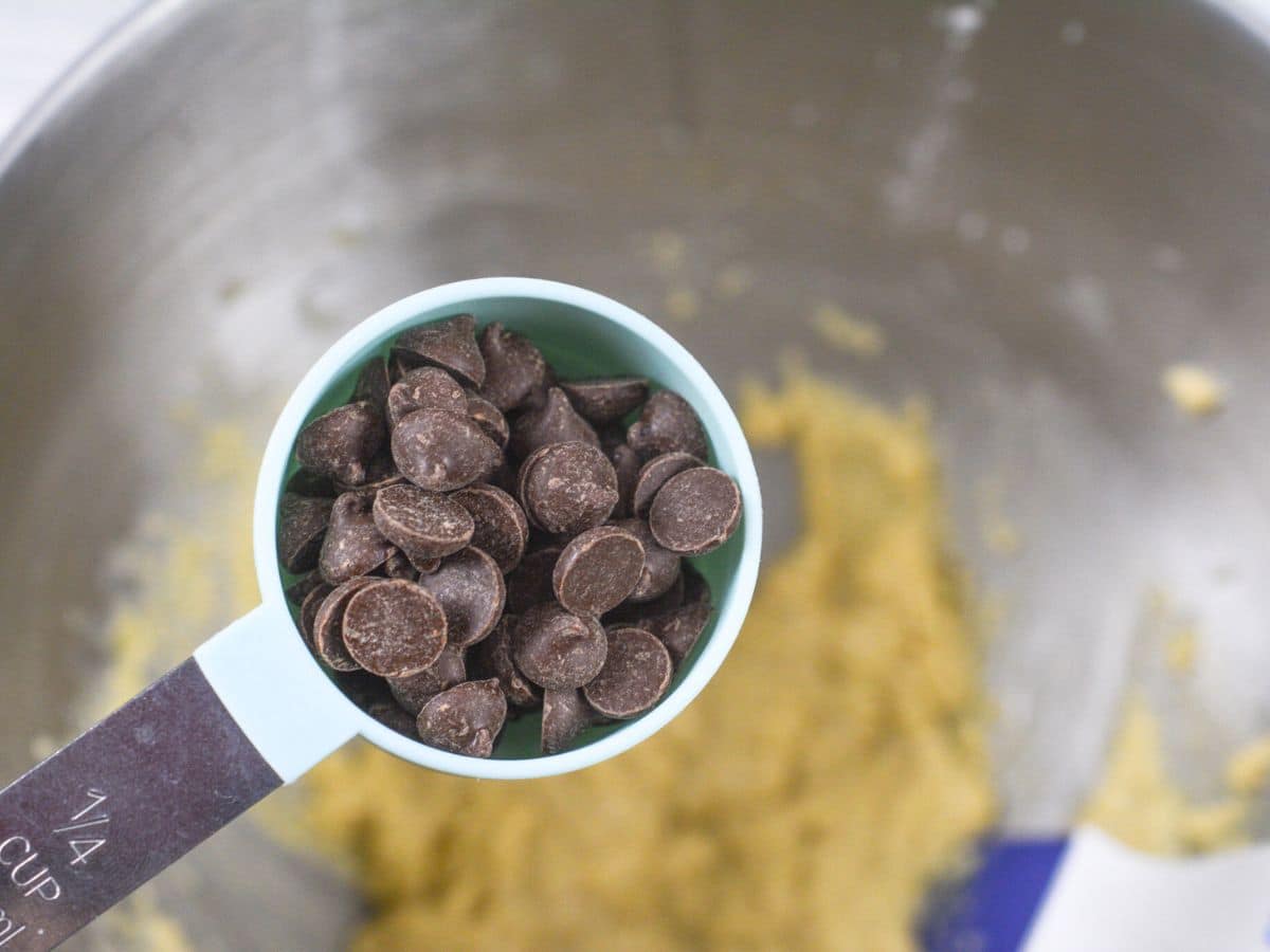 adding chocolate chips to cookie dough