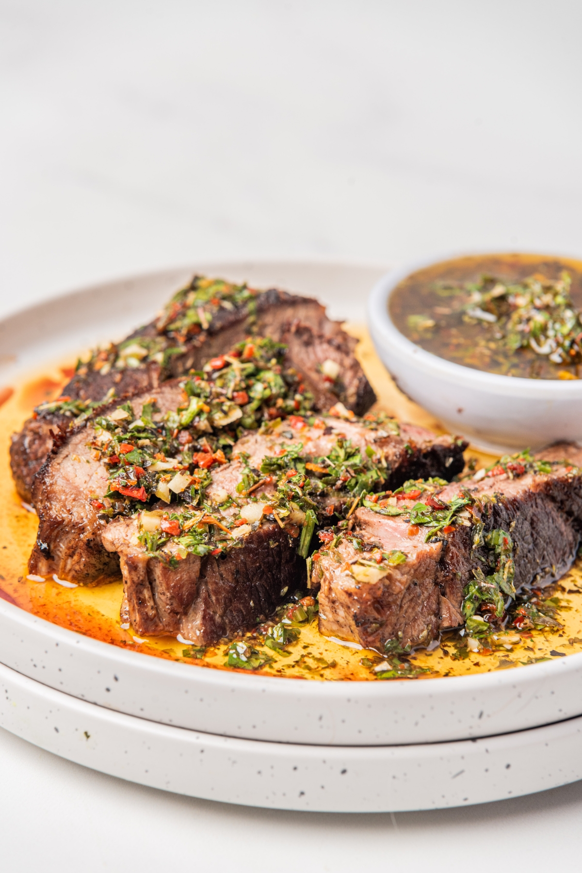steak on a plate with chimichurri