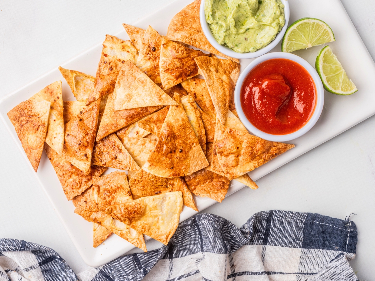 air fryer tortilla chips on a platter with dips