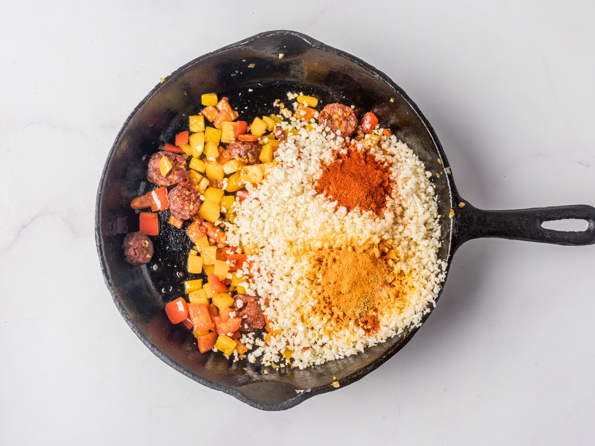 adding cauliflower rice in cast iron skillet