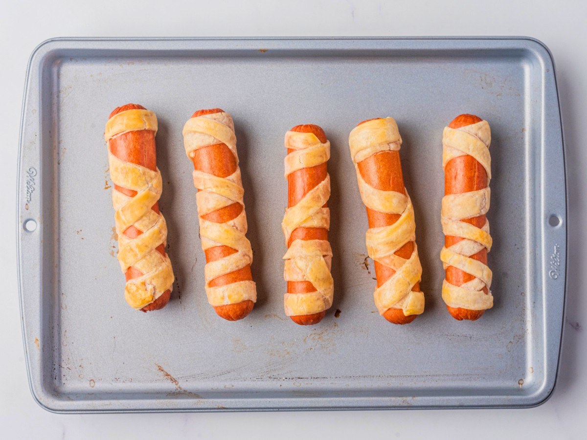 baked mummy dogs on a baking sheet. 