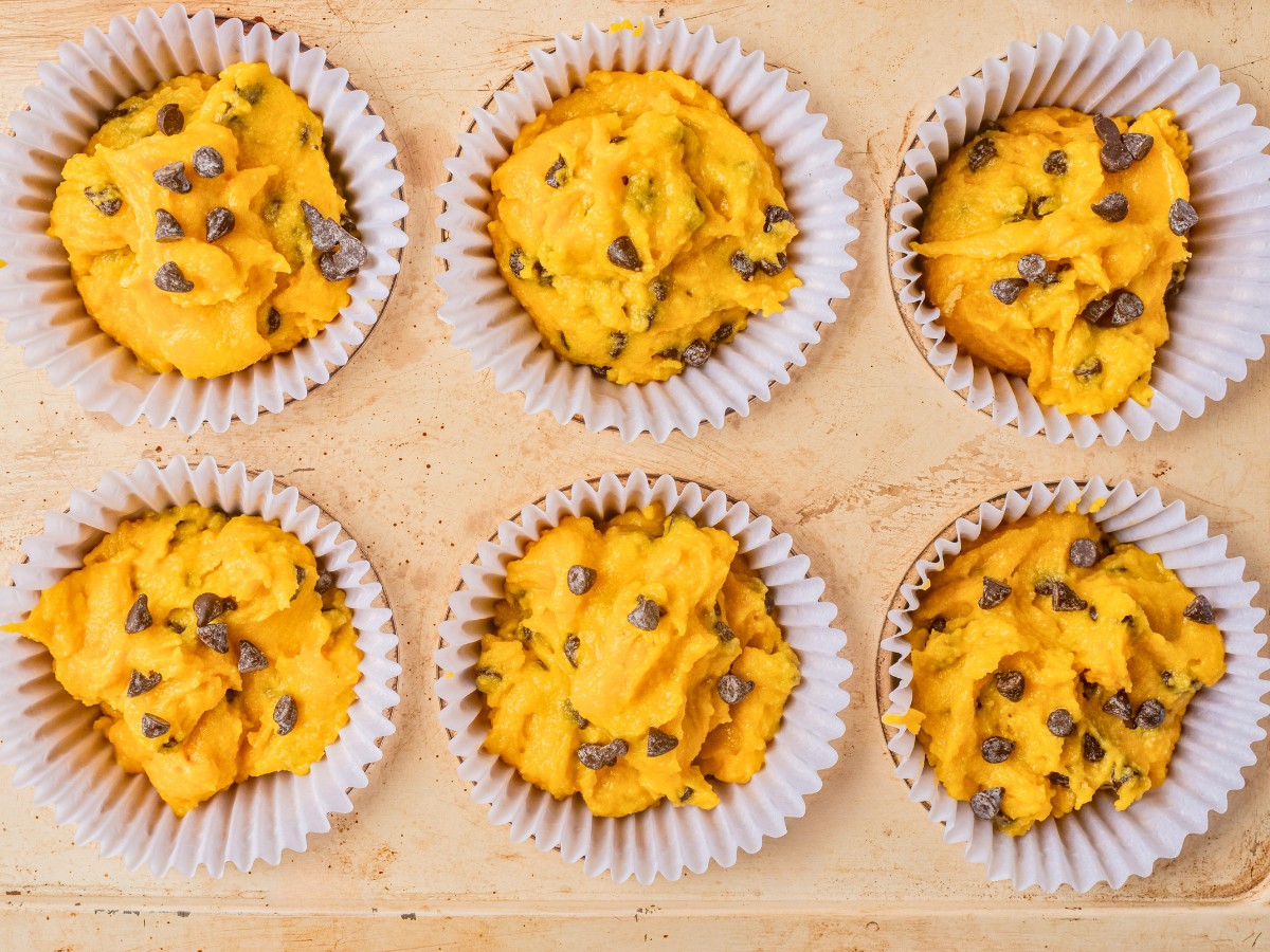 adding muffin mixture to baking sheet