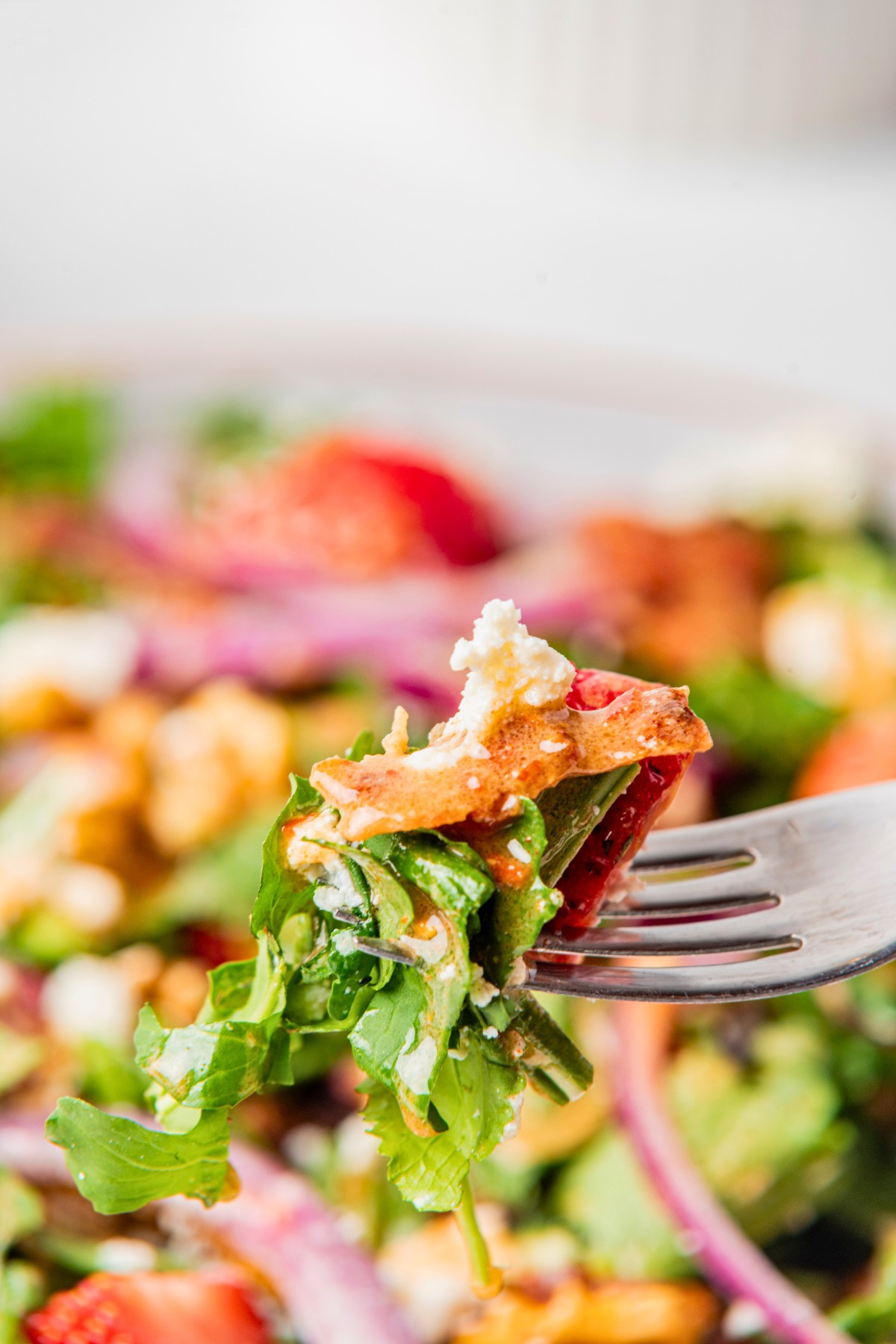 Close up of arugula and strawberry salad with goat cheese and bacon. 