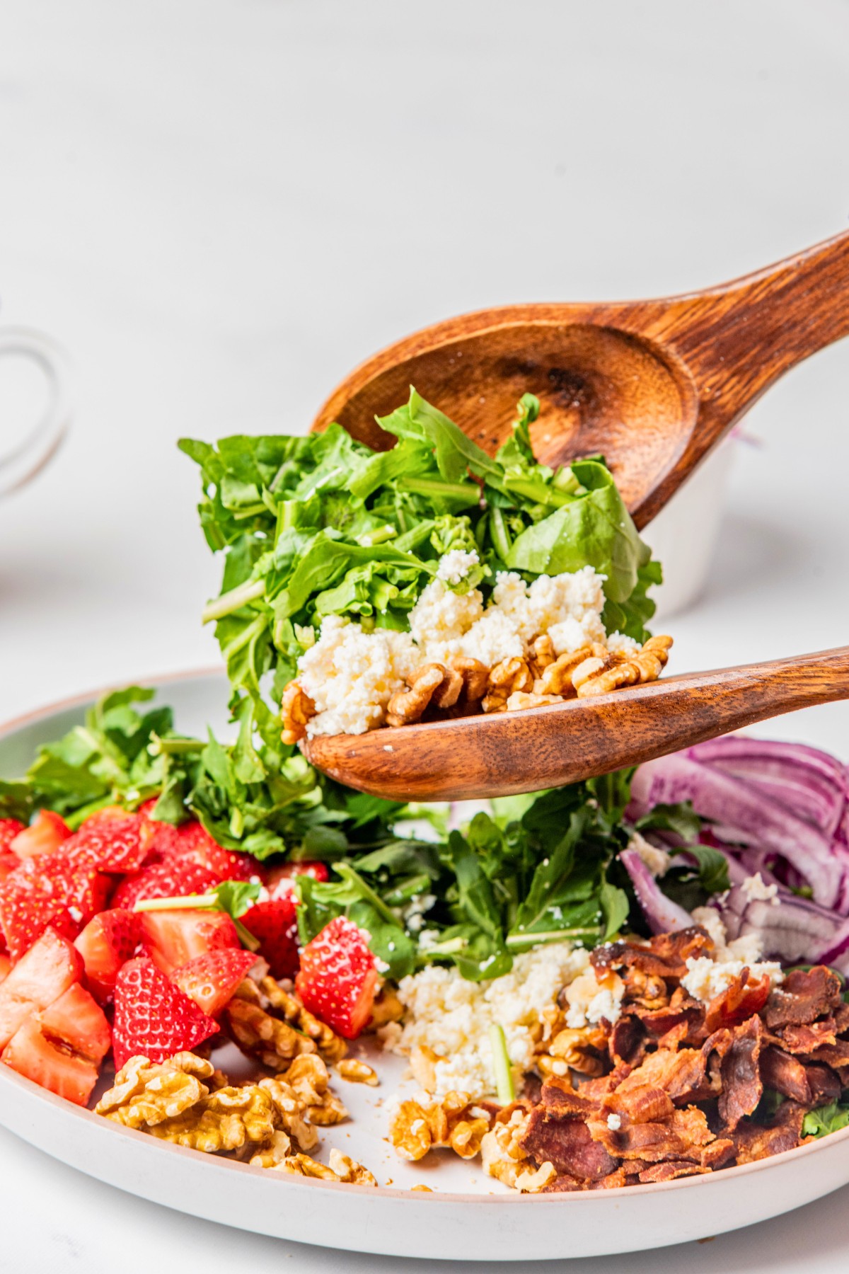 adding in goat cheese to arugula salad.