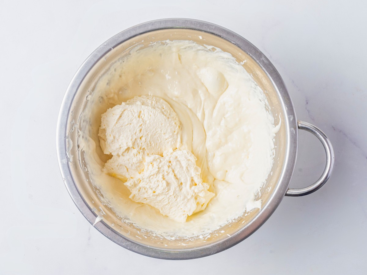 mixing whipped cream with cream cheese. 