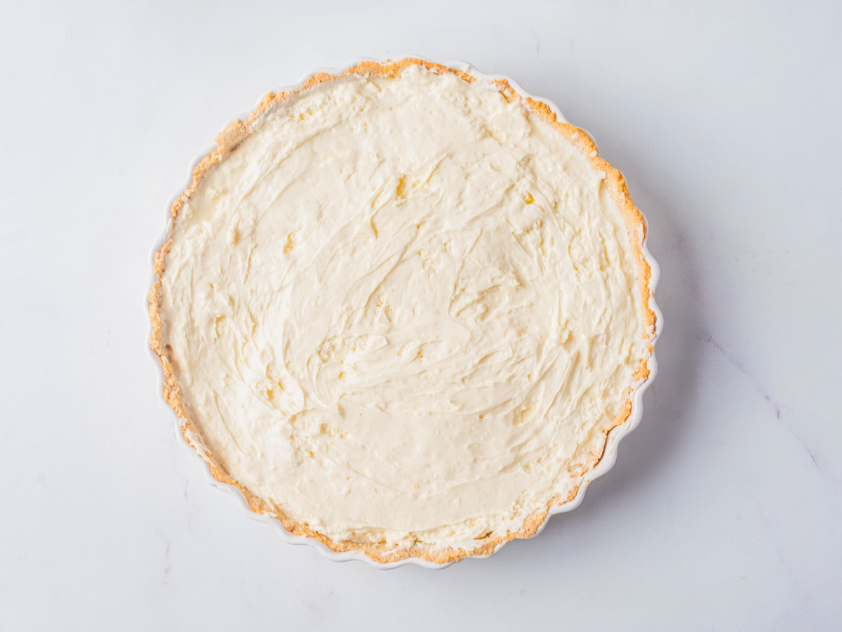 adding whipped cream on top of pie filling. 