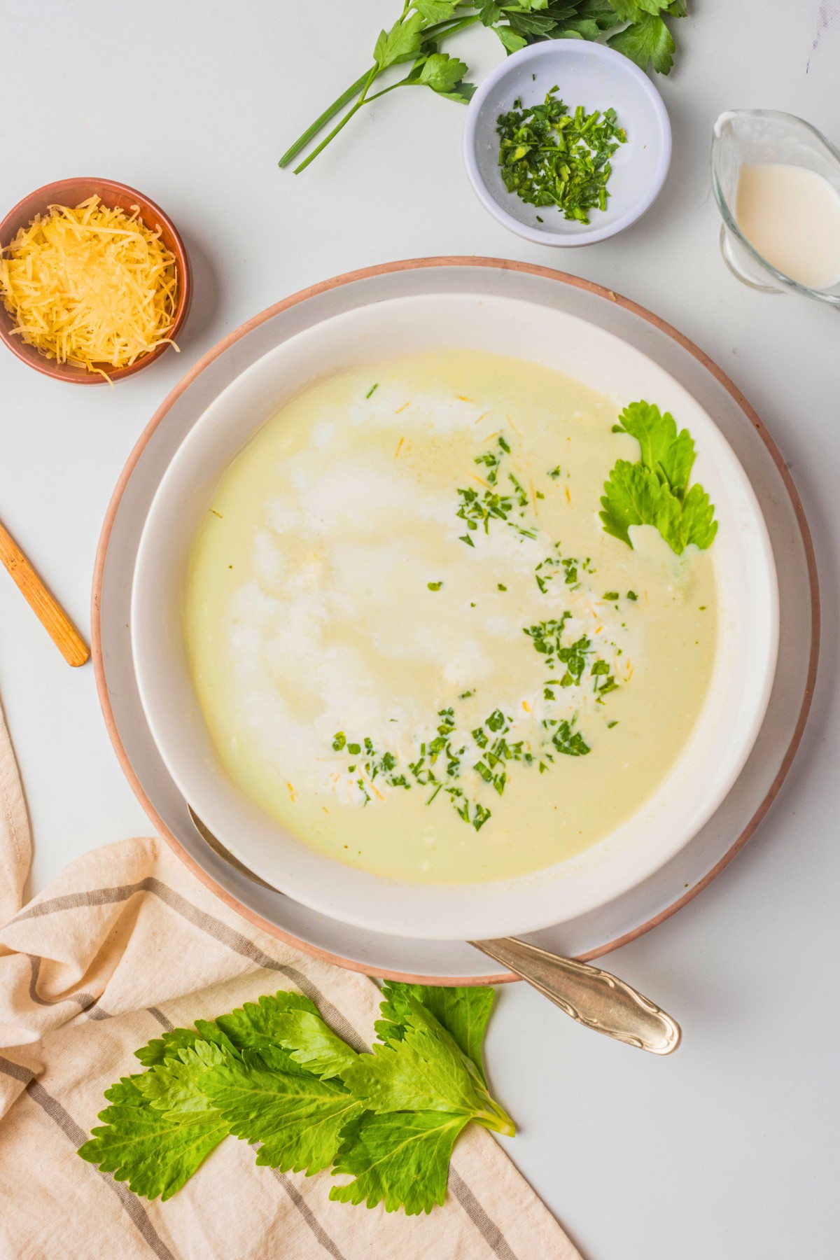 overhead shot of cream of celery soup recipe with celery leaves