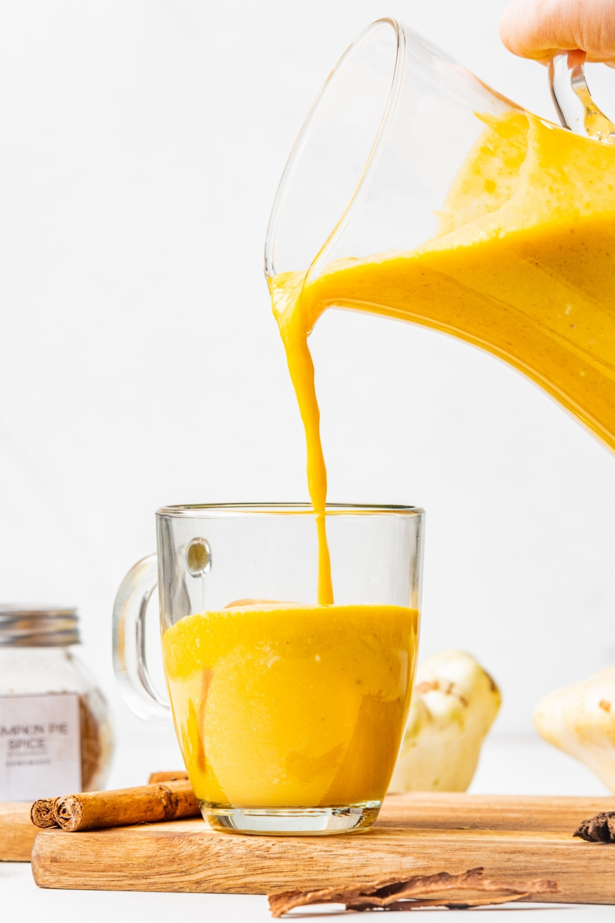 pouring keto pumpkin smoothie in a glass. 