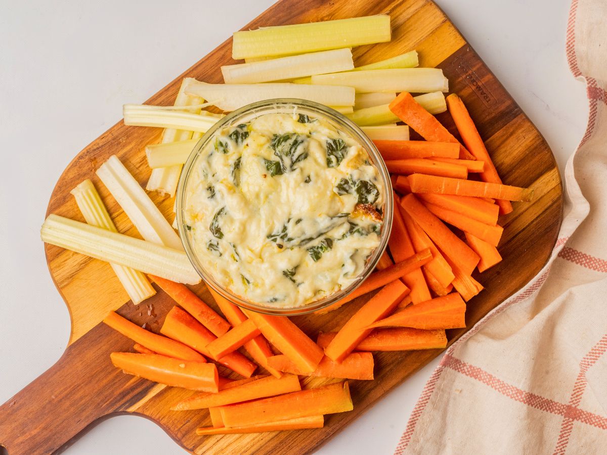 spinach dip in a bowl with cut up vegetables. 