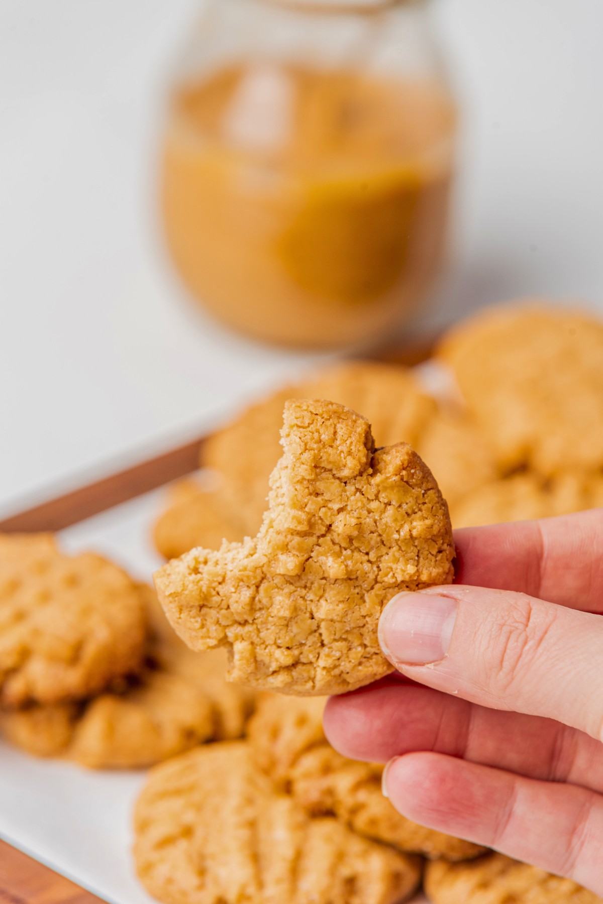 taking a bite of a sugar free peanut butter cookie. 