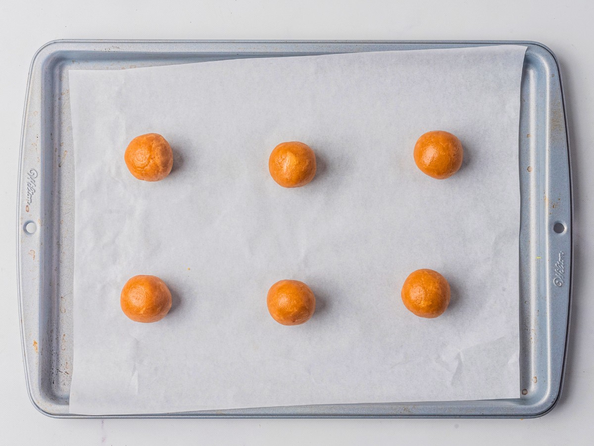rolled peanut butter balls on parchment paper. 