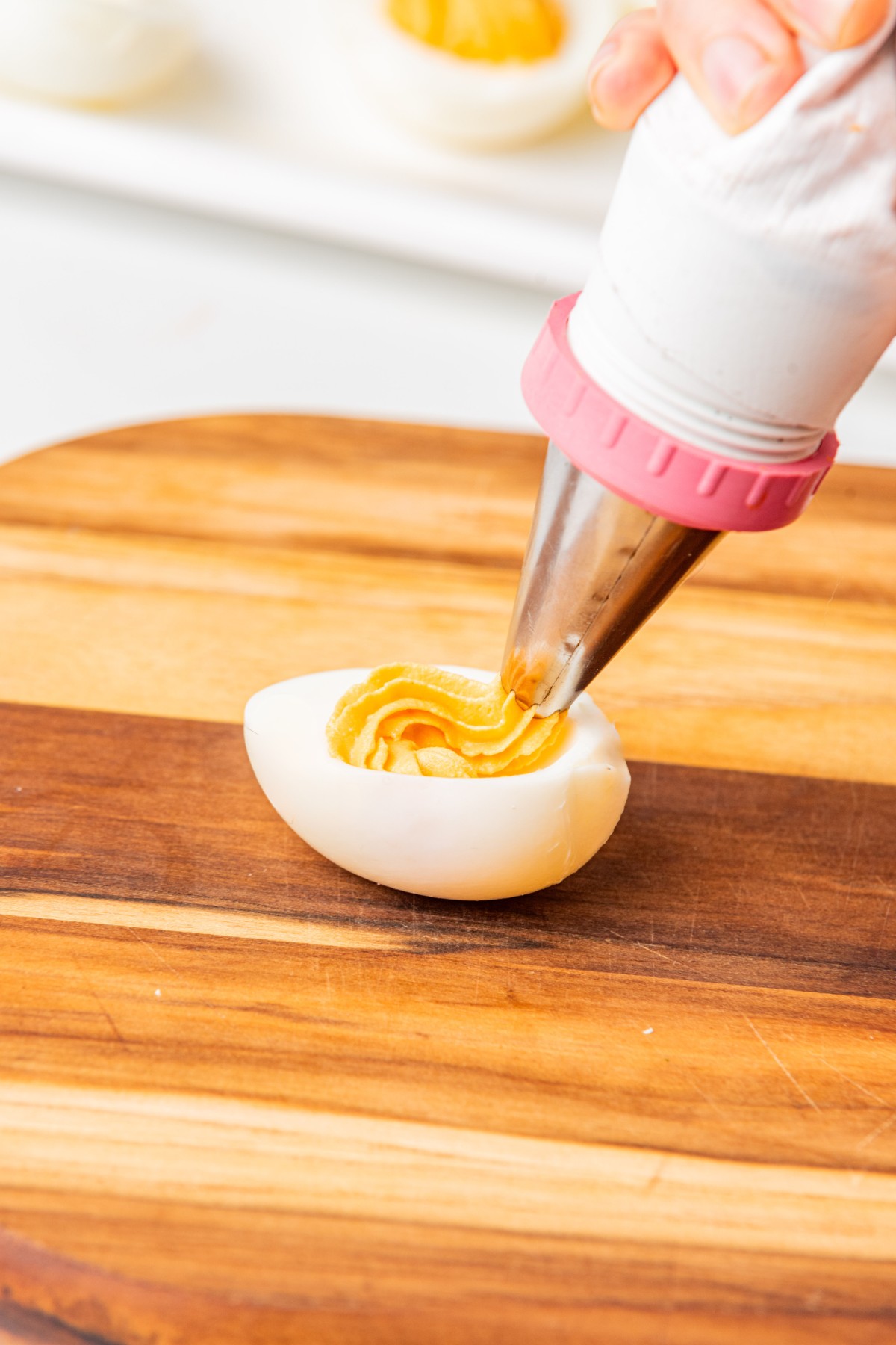 adding deviled egg filling to a piping bag. 