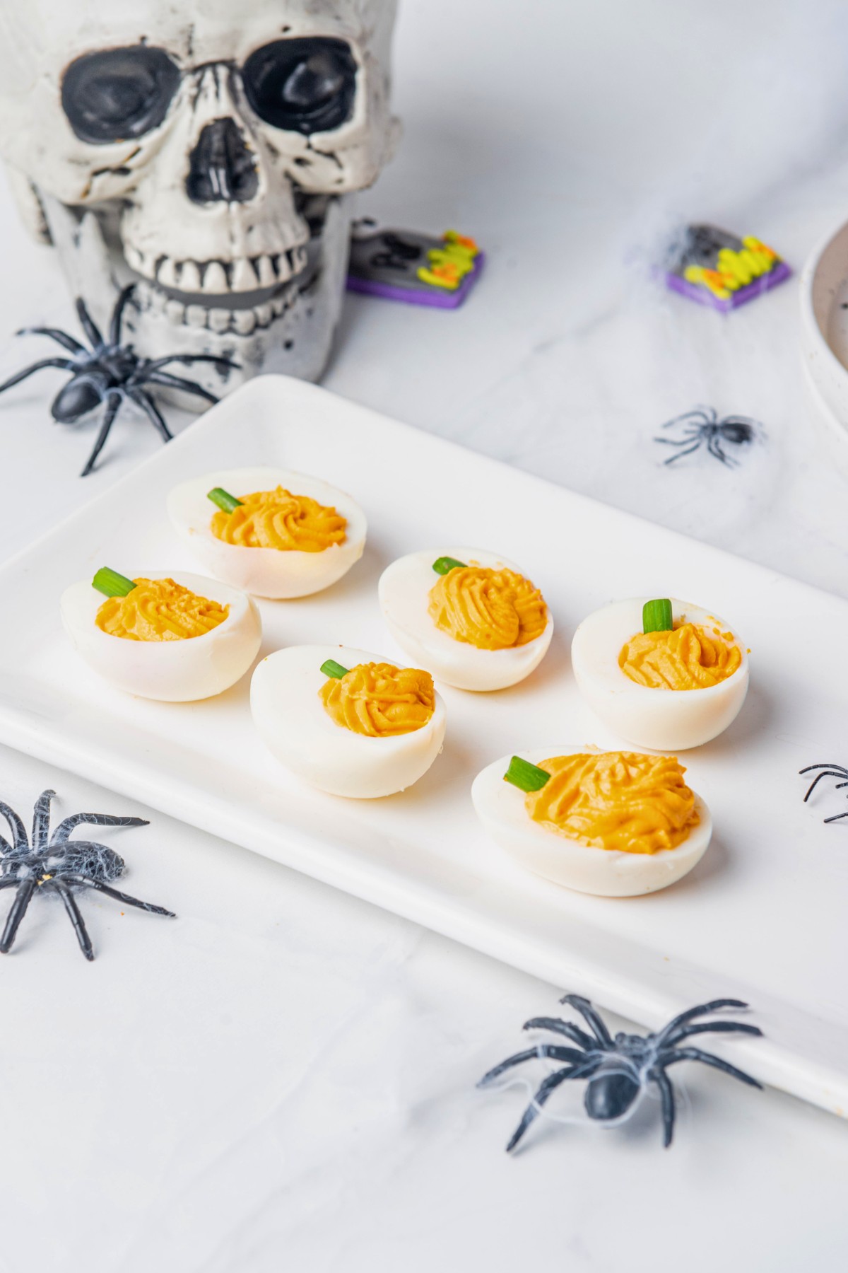 orange deviled eggs on a white platter. 