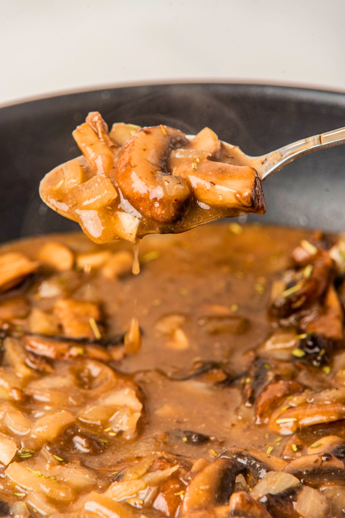 using a spoon to scoop mushrooms