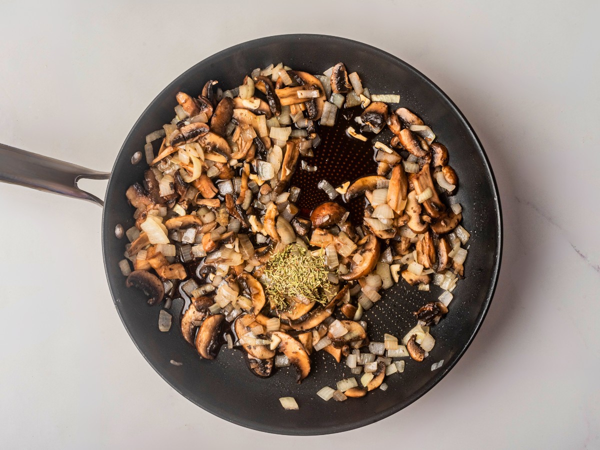 adding rosemary and herbs to sauteed mushrooms