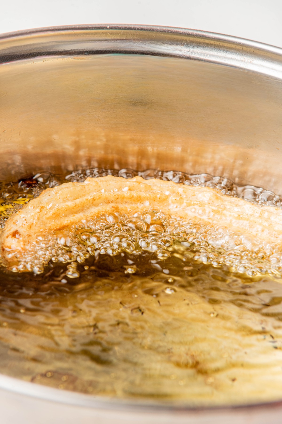 frying a keto churro in a pan of hot coconut oil