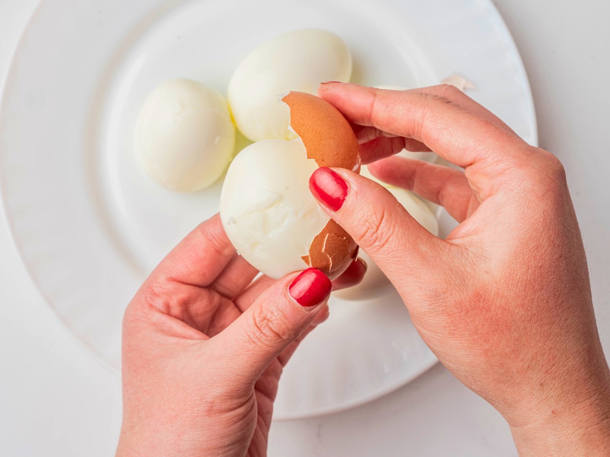 peel hard boiled eggs with hands 