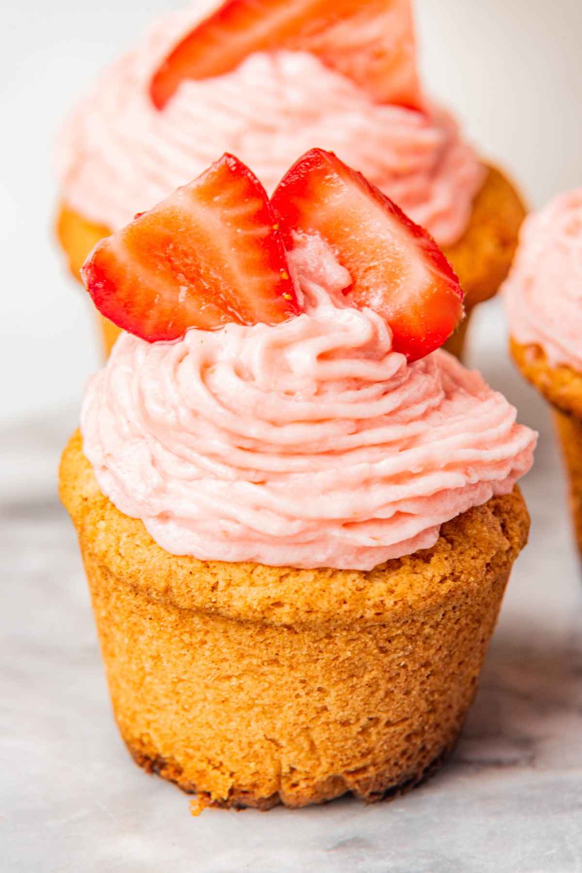 close up of a cupcake with strawberry cream cheese frosting