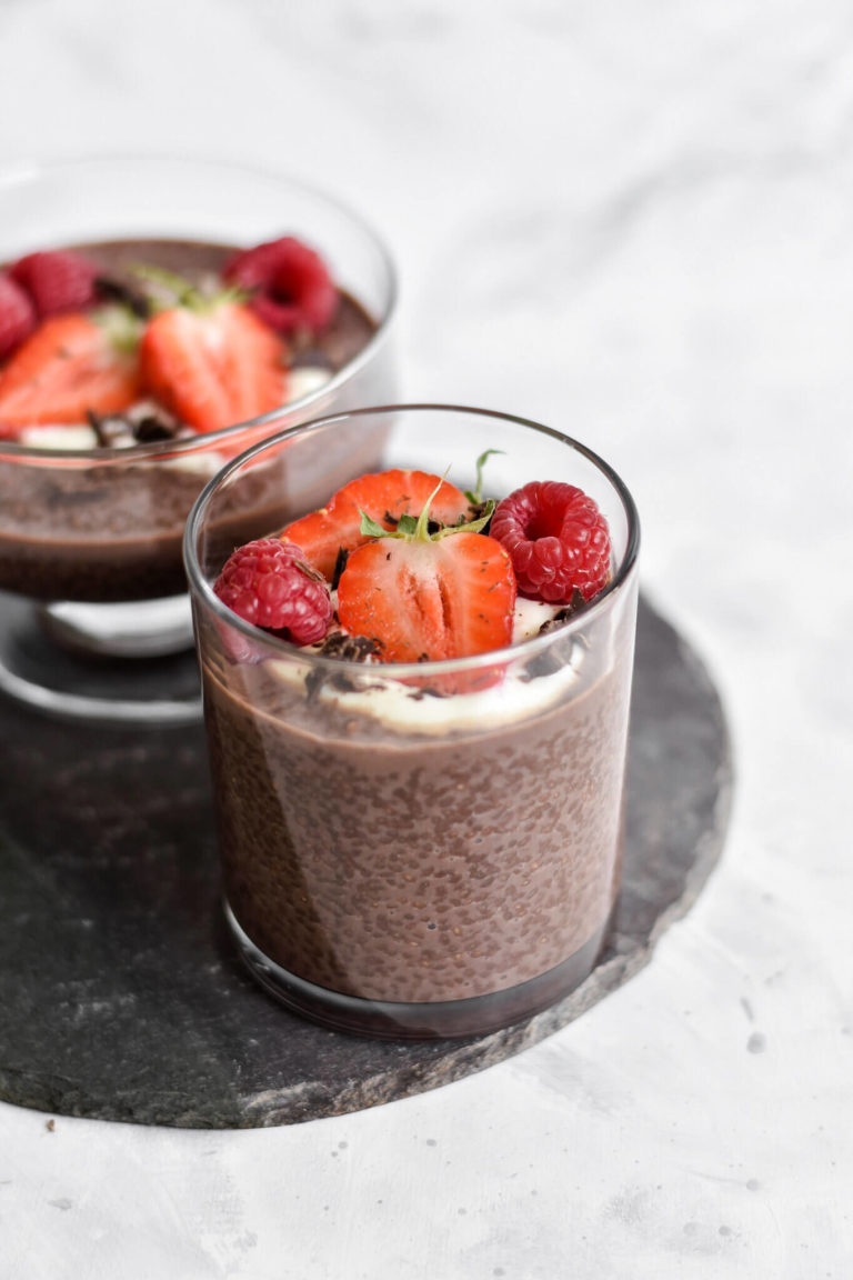 a cup of chocolate chia seed pudding with cut up strawberries. 