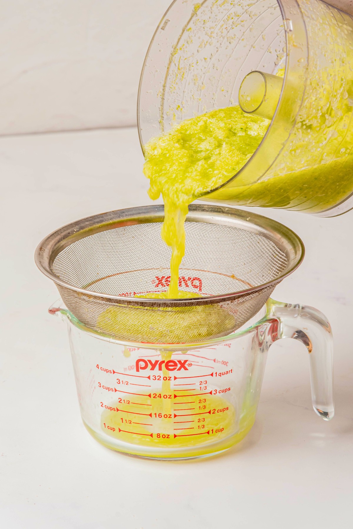 pouring juice mixture into strainer