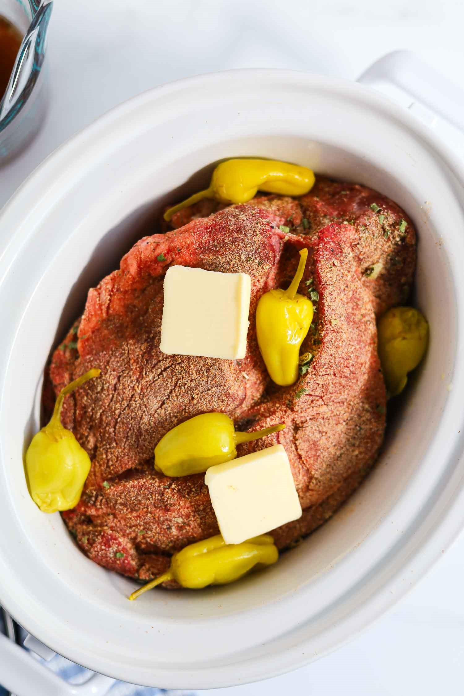 pepperoncini peppers and butter added to the chuck roast in a crockpot.